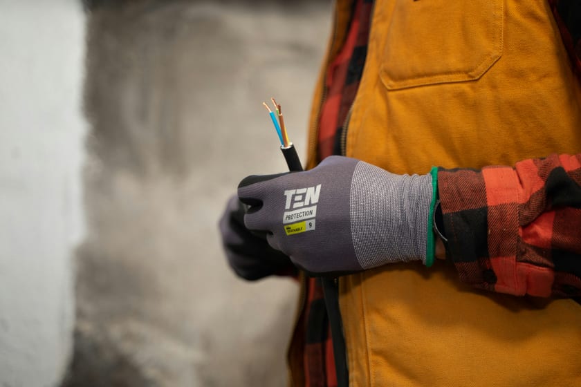 Electrician holding wiring cables on a job site — property maintenance and field operations support